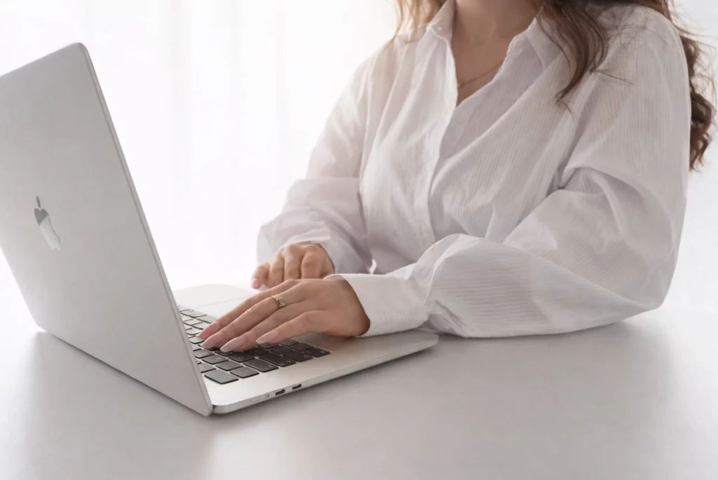 Frau sitzt am Laptop und tippt.